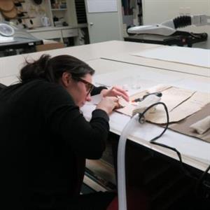 Kat Fanning repairs a family tree document from the Leo Baeck Institute collection at the Center for Jewish History