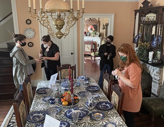 Group of people surveying items in historic house